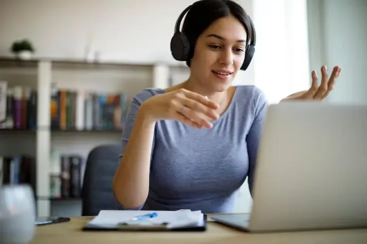 Woman using headset and laptop for remote support, representing effective contact center outsourcing services across communication channels.